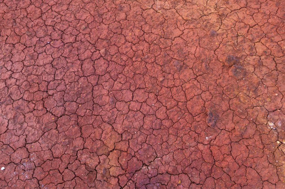 Free Image of A red cracked ground with cracks 