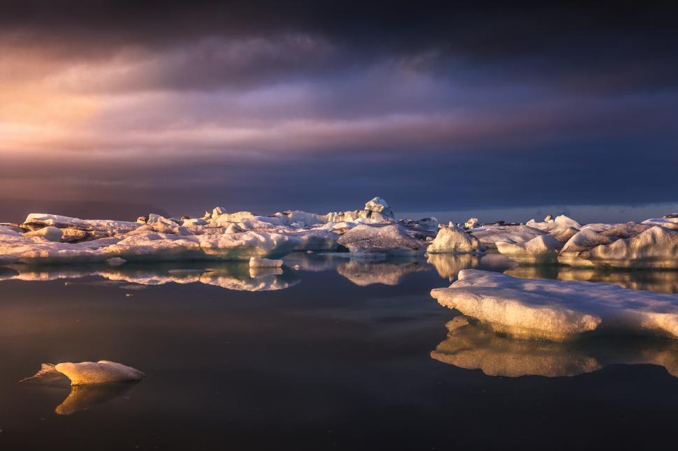 Free Image of Icebergs in the water with a cloudy sky 