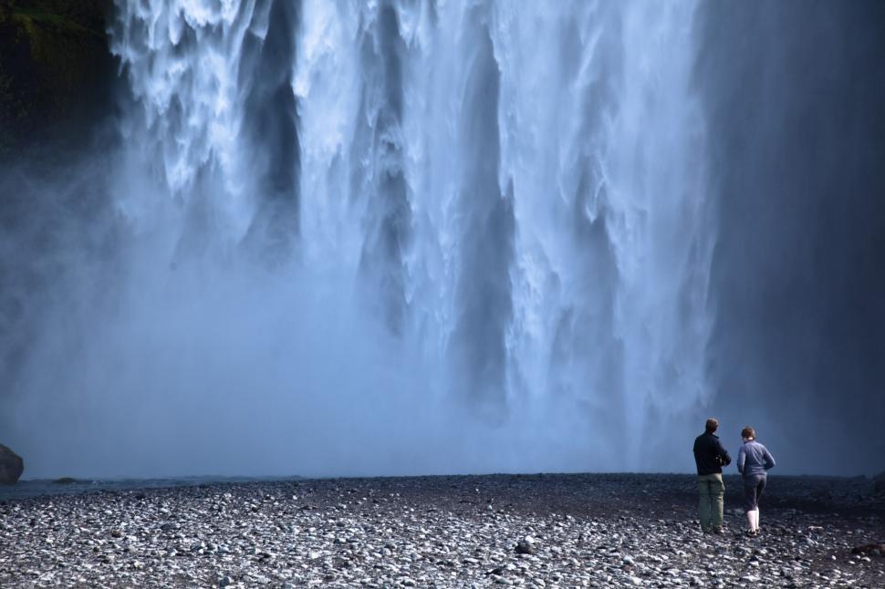 Free Image of A man standing in front of a waterfall 