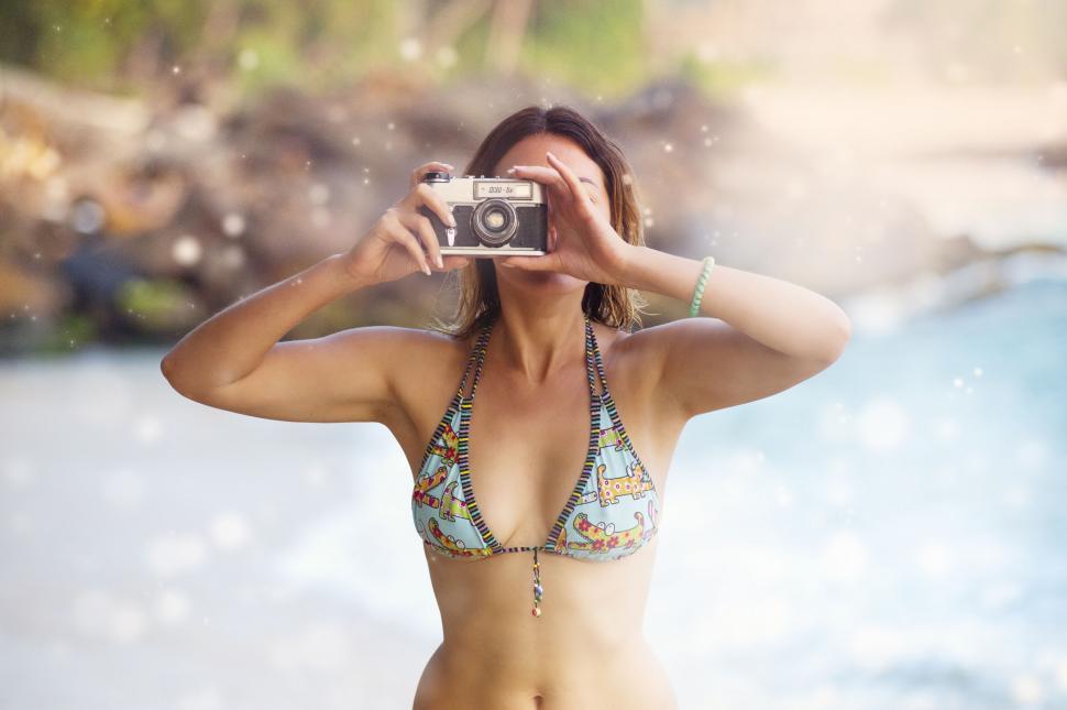 Free Image of A woman in a garment taking a picture with a camera 