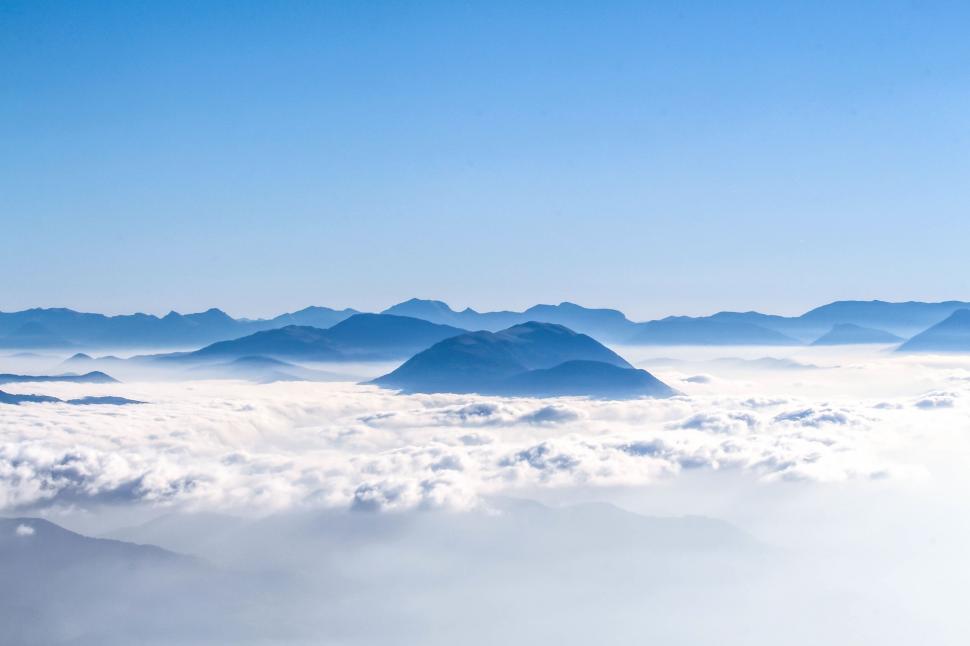 Free Image of A mountain range with clouds and blue sky 