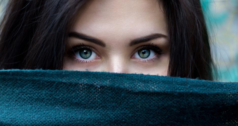 Free Image of A woman with green eyes covering her face 