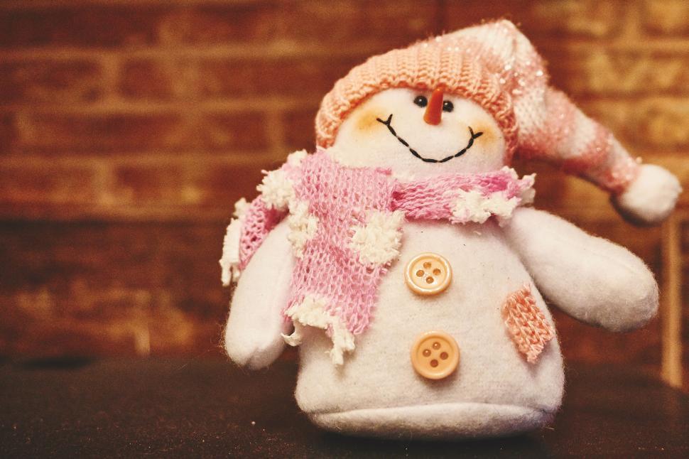 Free Image of A snowman doll with a scarf and hat 