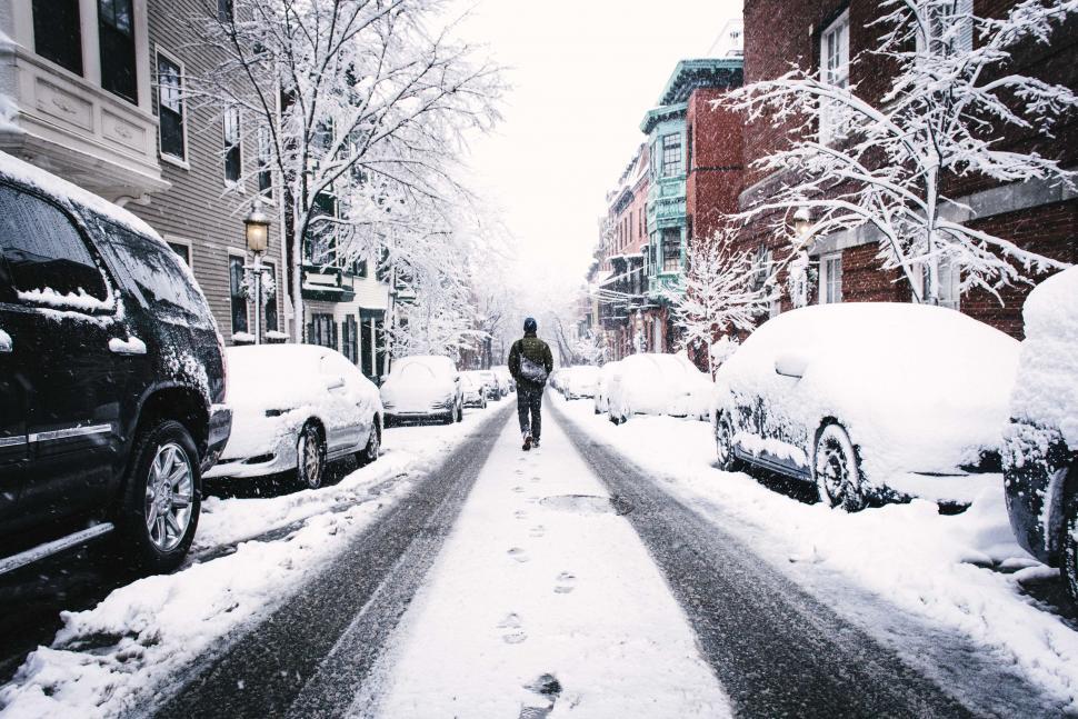 Free Image of A person walking on a snowy street 