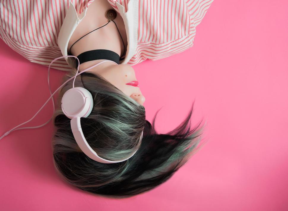 Free Image of A woman lying on her back wearing headphones 