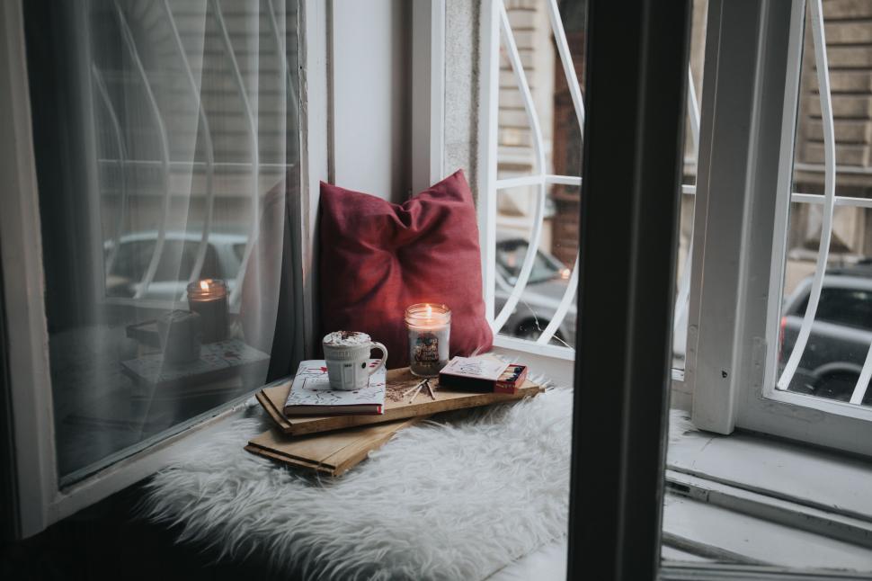 Free Image of A cup of coffee and a book on a window sill 