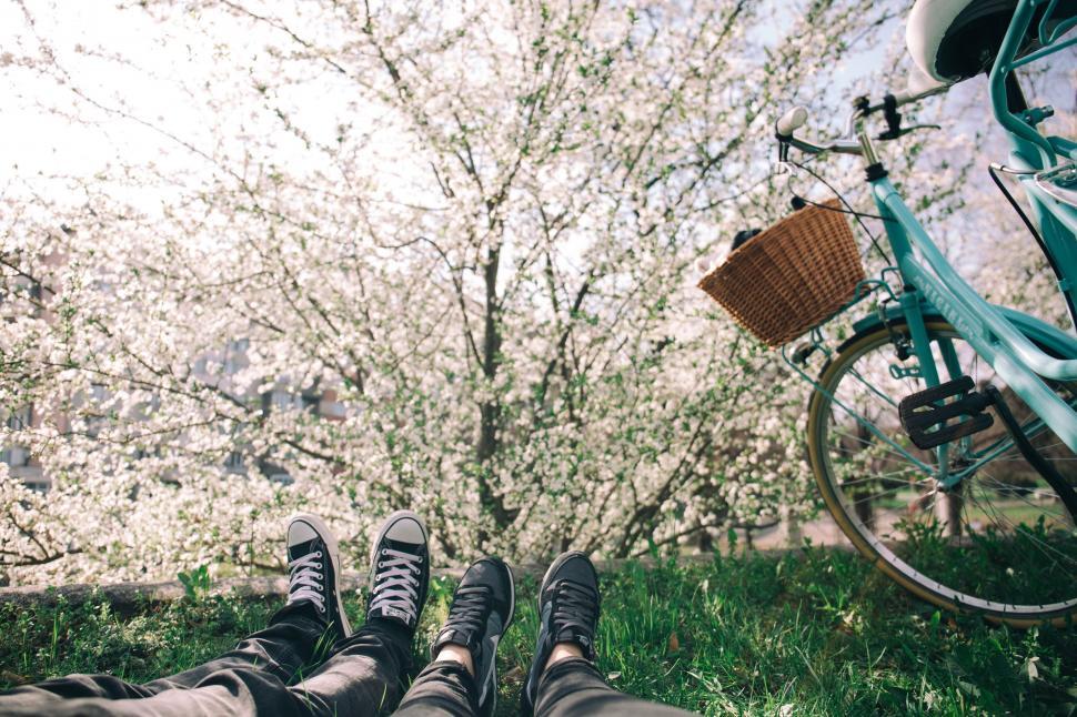 Free Image of A person s legs and a bicycle in the grass 