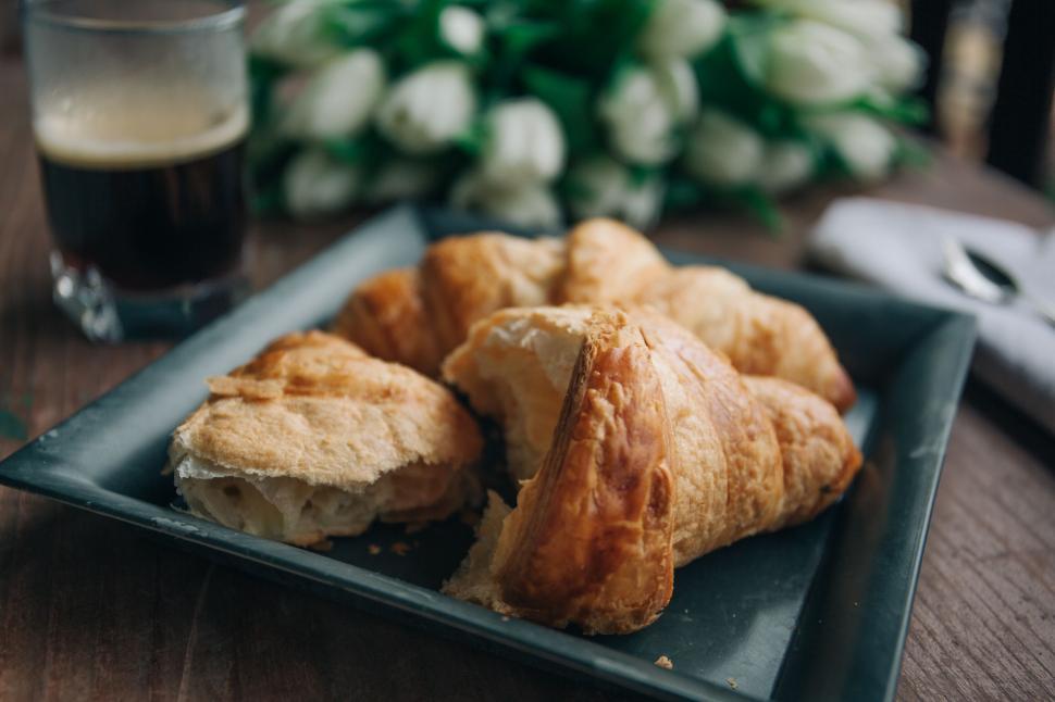Free Image of A plate of croissants and a glass of liquid 