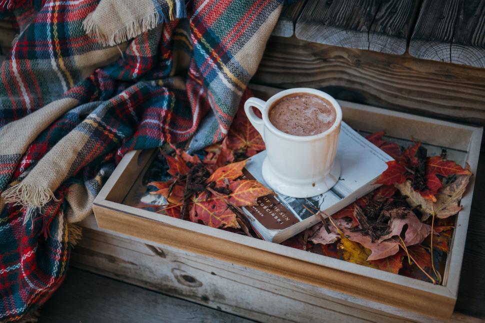 Free Image of A cup of hot chocolate on a tray with leaves and a blanket 