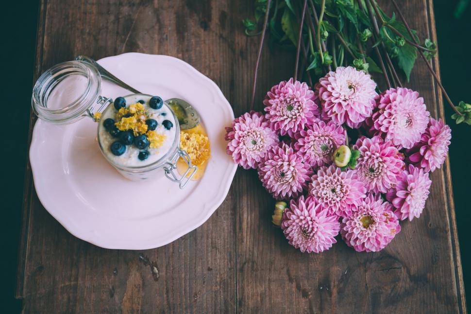 Free Image of A plate with a glass of yogurt and flowers on it 
