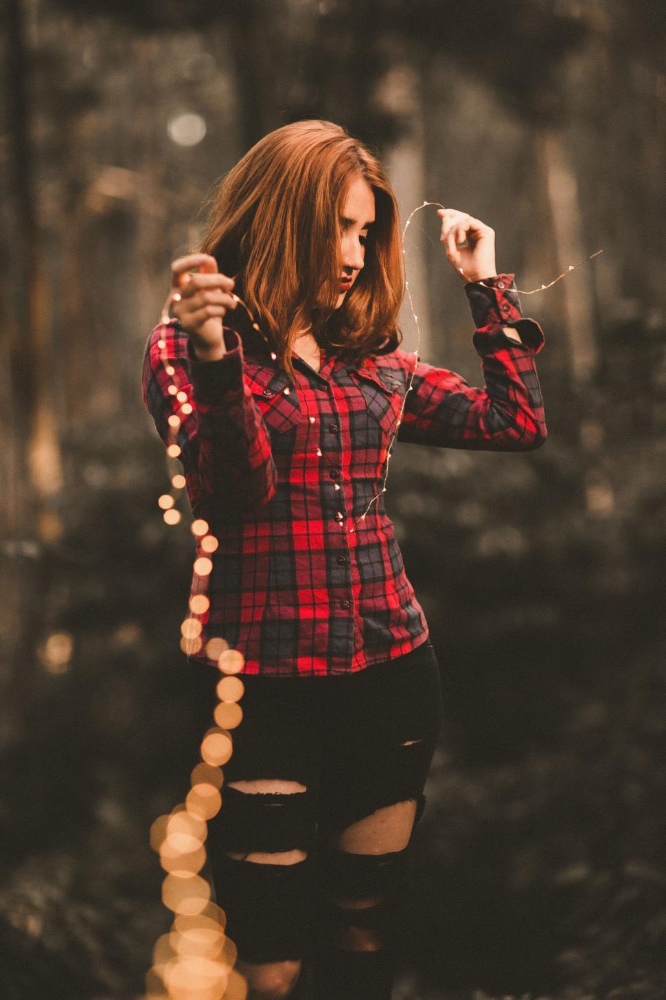 Free Image of A woman holding a string of lights 