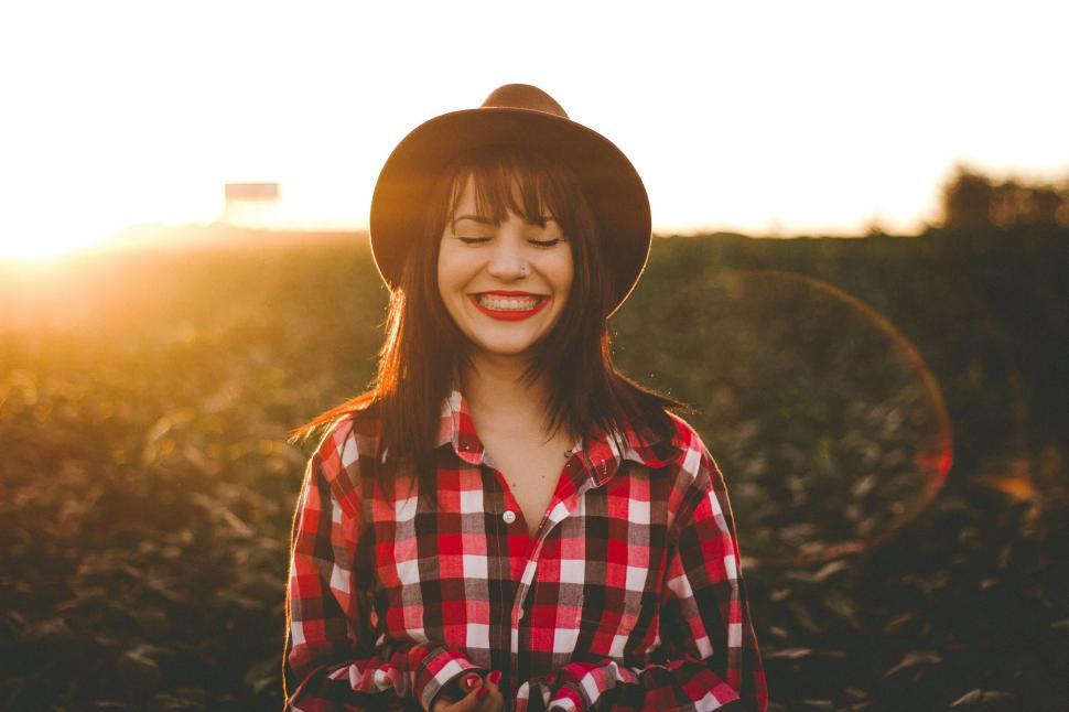 Free Image of A woman wearing a hat and red flannel smiling 