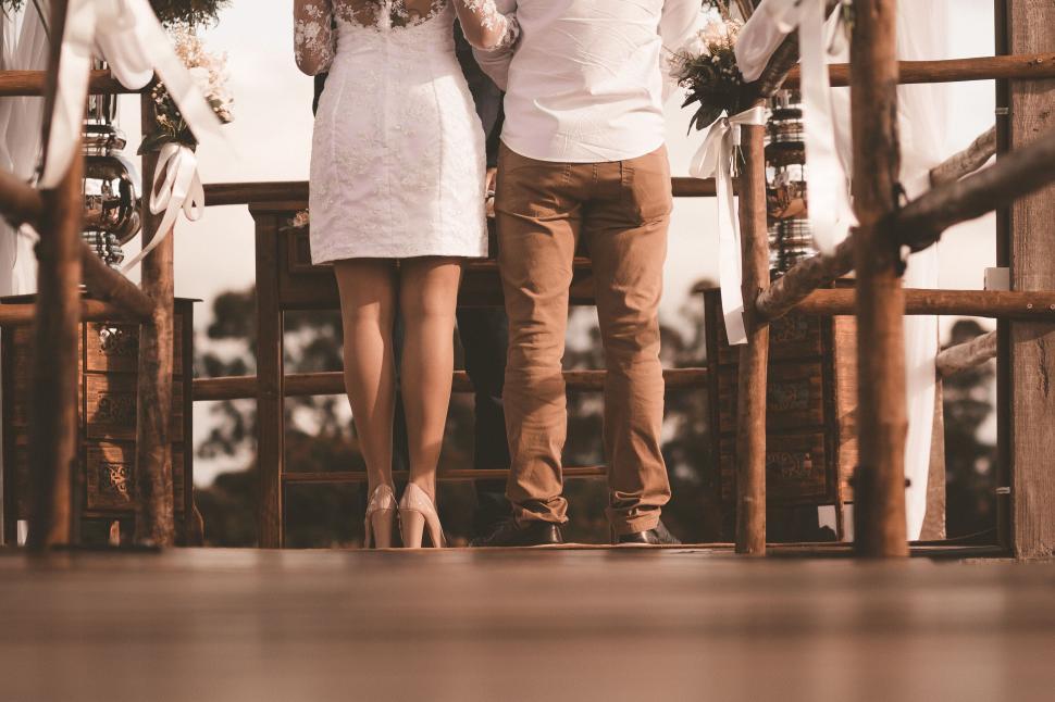 Free Image of A man and woman standing on a wooden deck 