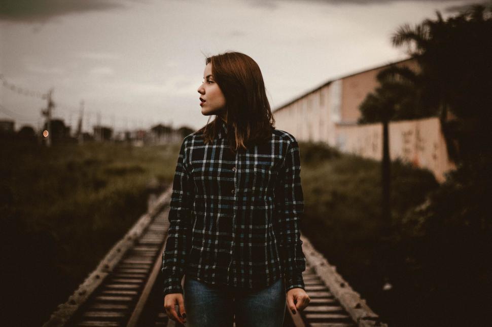 Free Image of A woman standing on a train track 