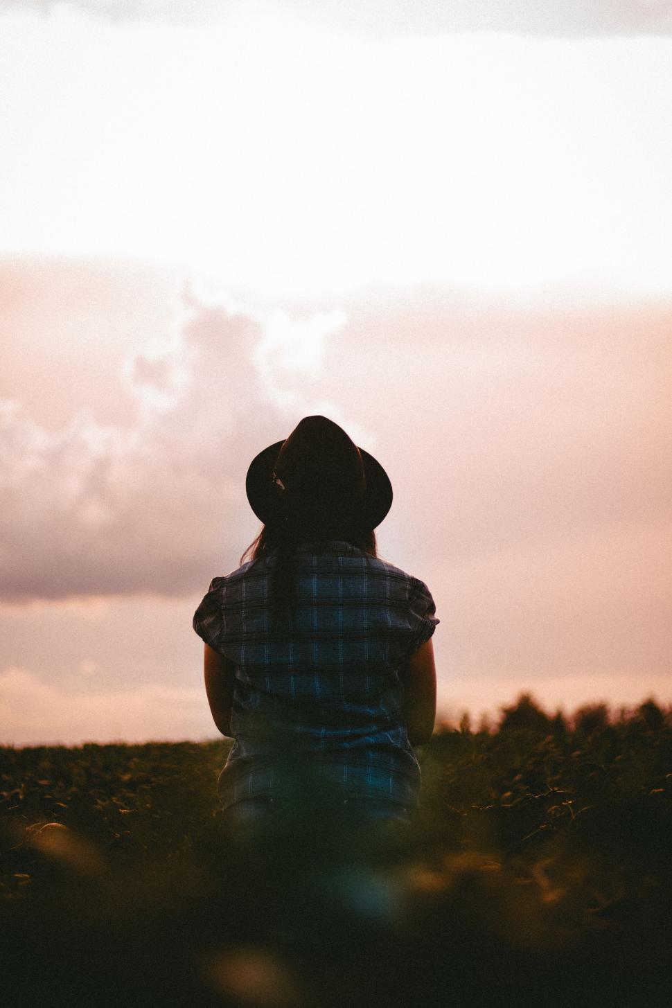 Free Image of A person in a hat looking at the sky 