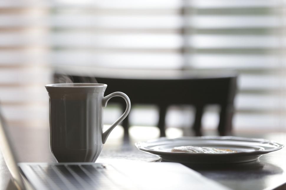 Free Image of A cup of coffee and a plate of food on a table 