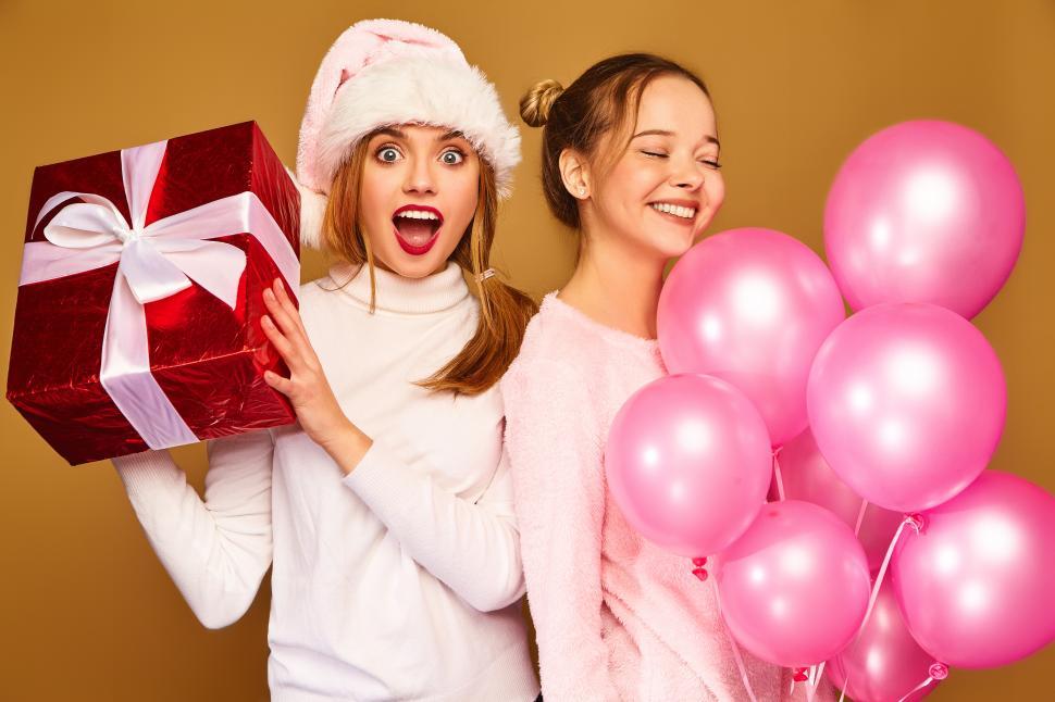 Free Image of Two women holding a gift and balloons 
