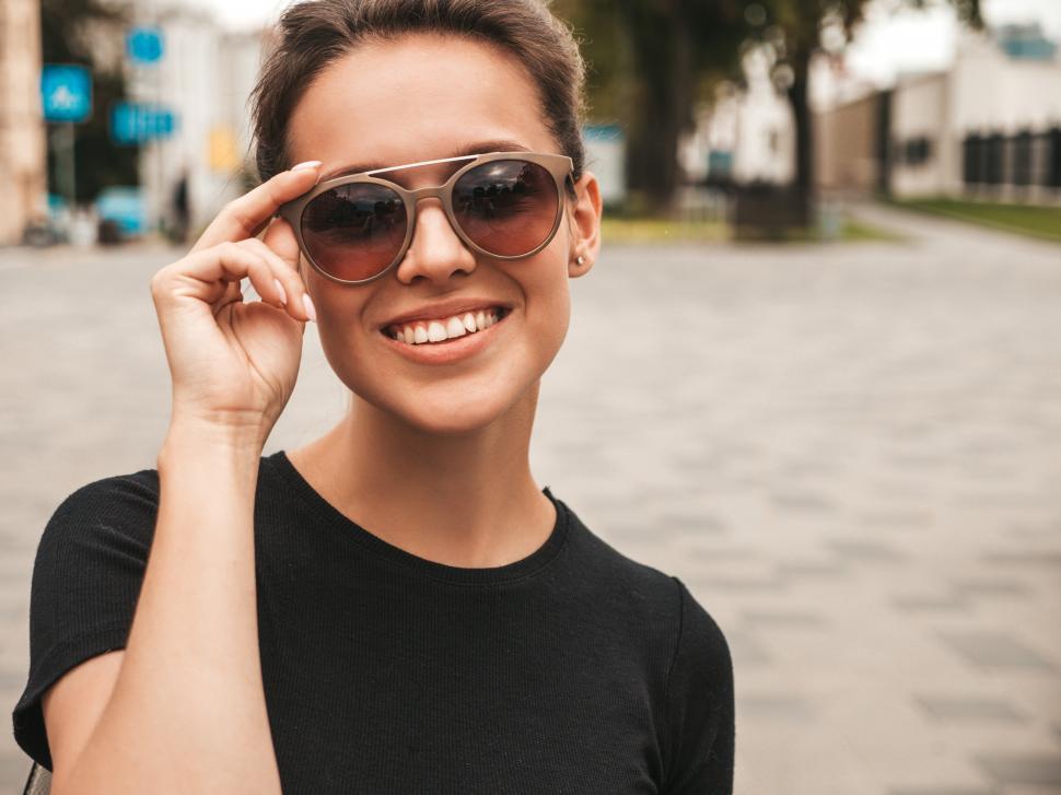 Free Image of A woman wearing sunglasses smiling 
