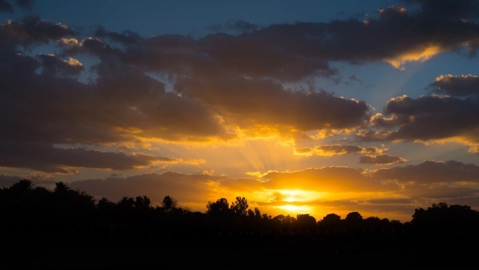 Free Image of A sunset with clouds and trees 