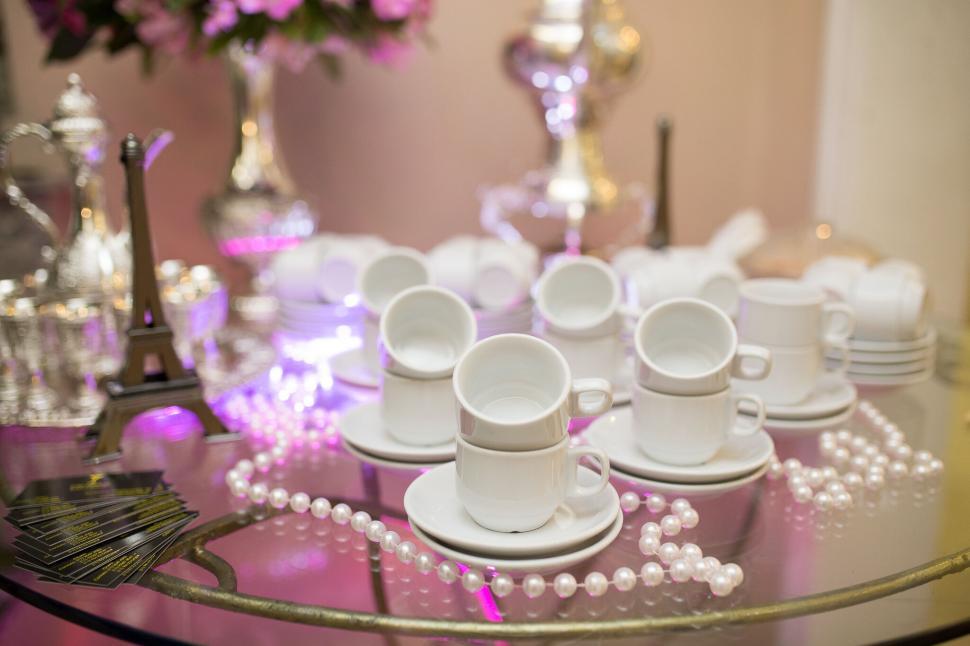 Free Image of A group of white cups and saucers on a glass table 