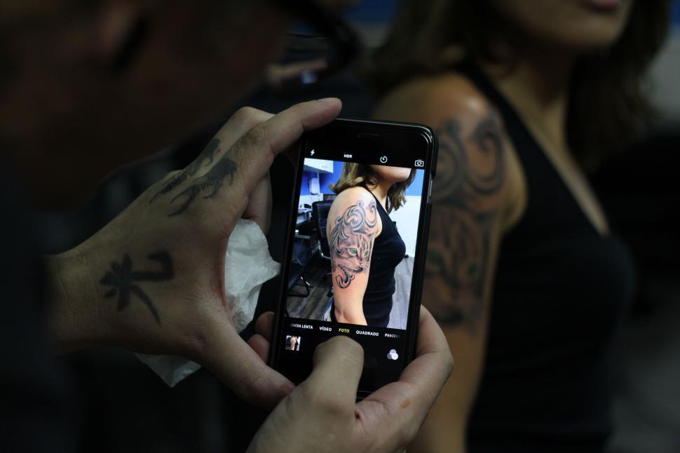 Free Image of A person taking a picture of a woman s arm 