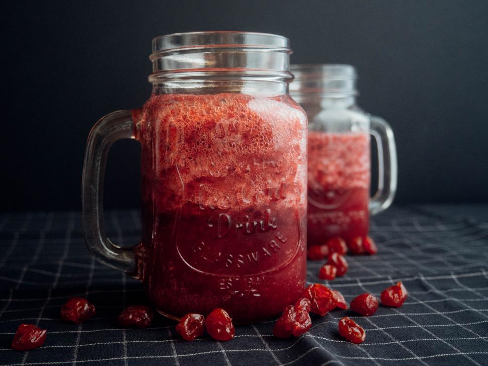 Free Image of A glass mugs filled with red liquid and dried cherries 