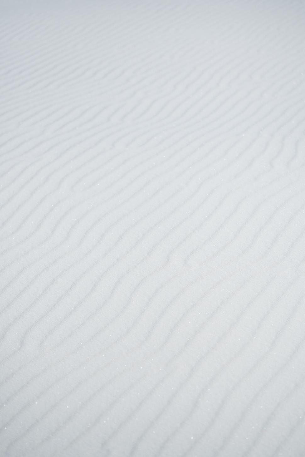 Free Image of A white sand with wavy lines 