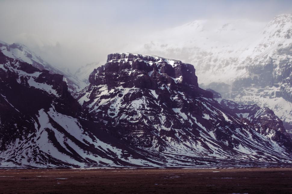 Free Image of A snowy mountain with a flat field 