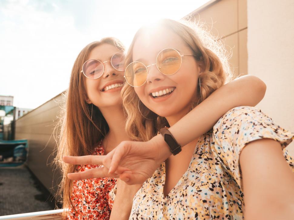 Free Image of Two women wearing sunglasses and smiling 