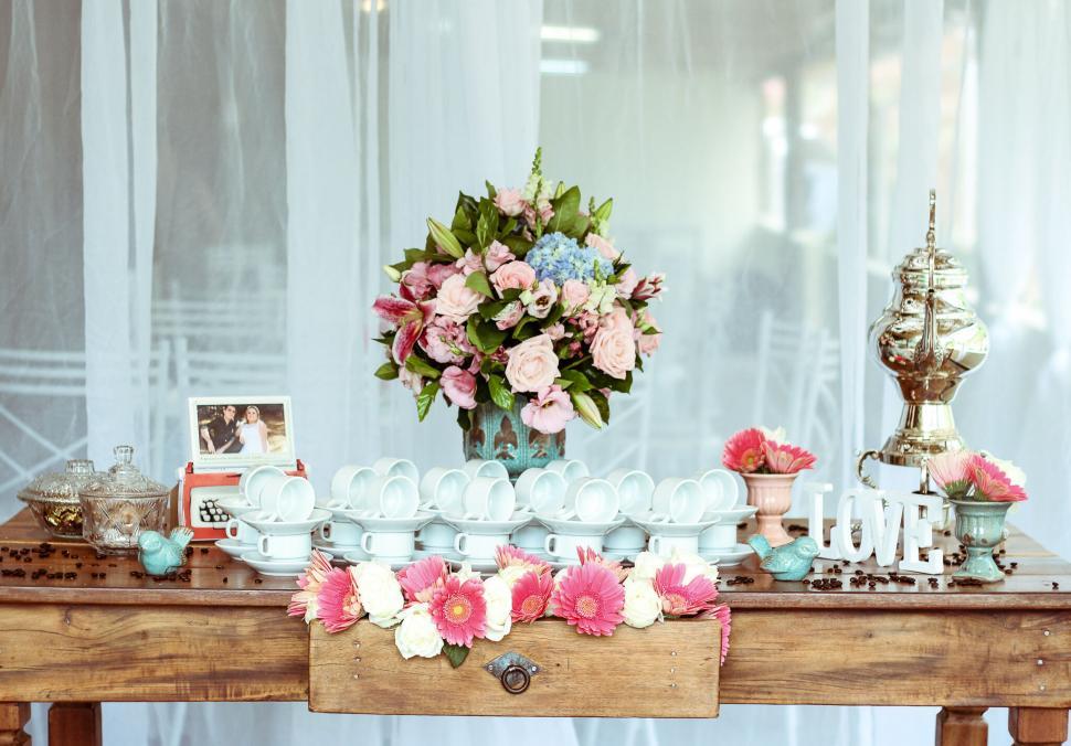 Free Image of A table with a vase of flowers and cups 