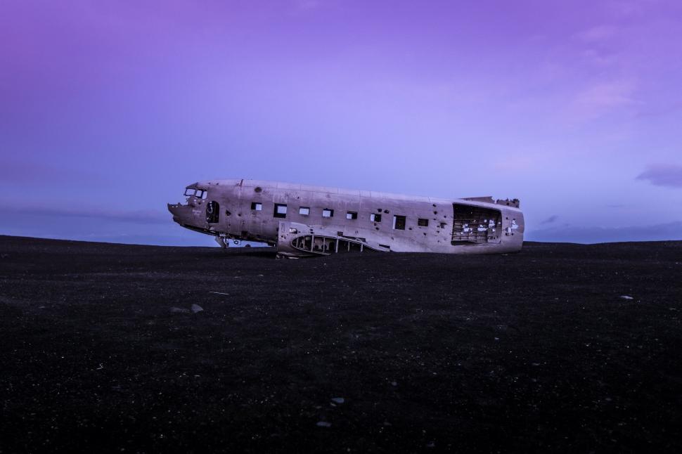 Free Image of A plane wreck on a black sand beach 