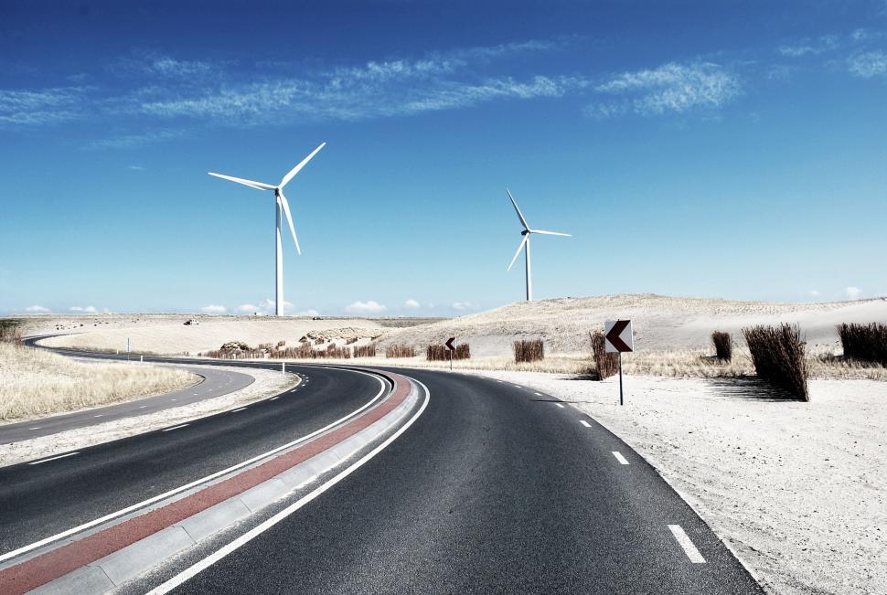 Free Image of A road with wind turbines in the distance 