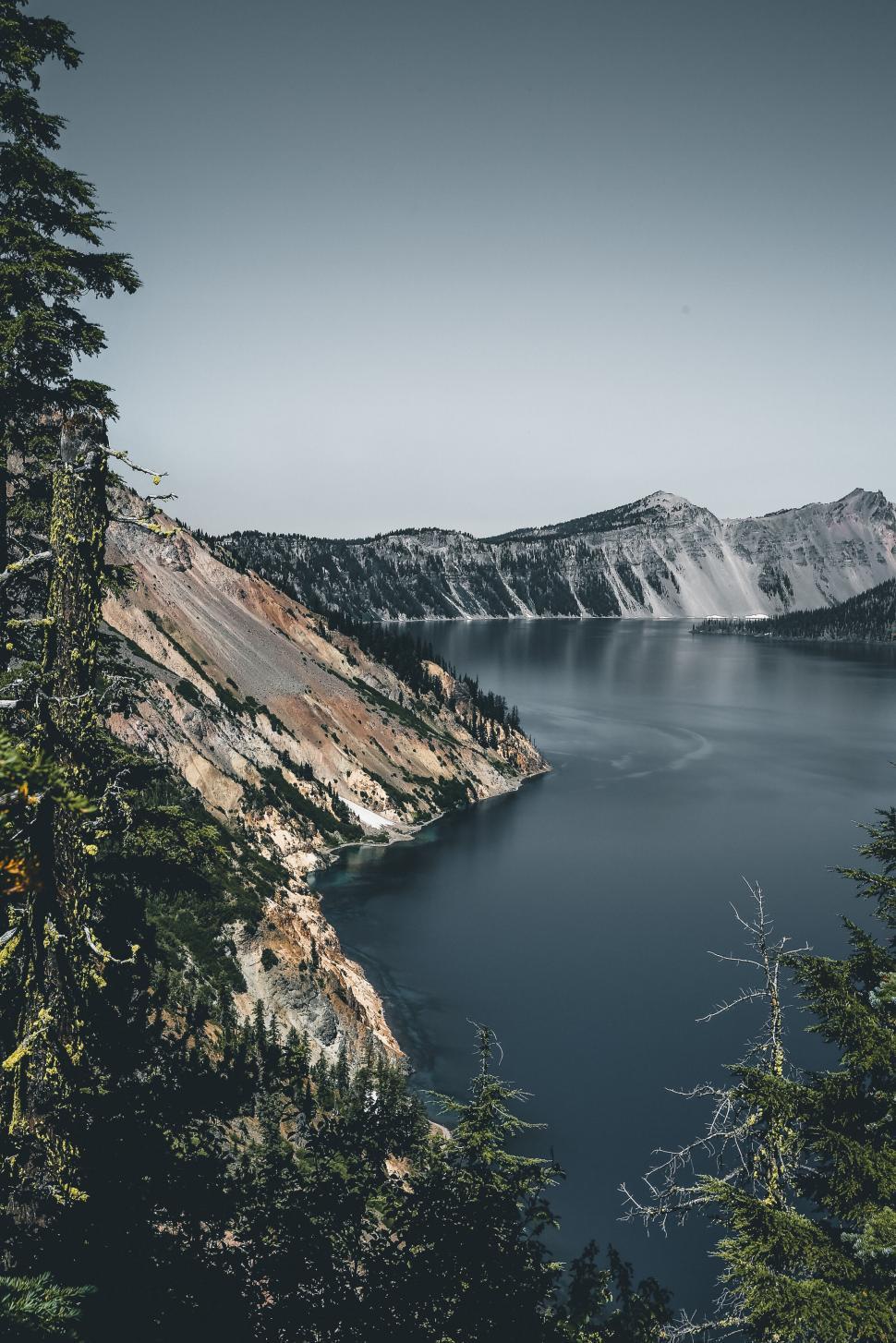 Free Image of A body of water with trees and mountains in the background 