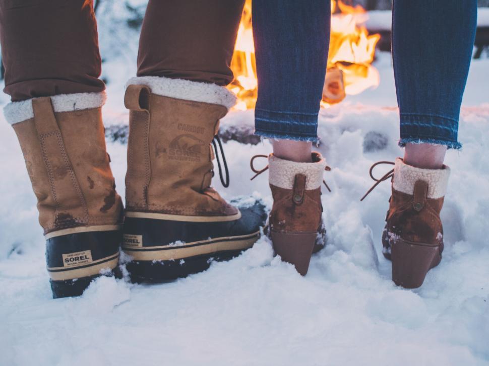 Free Image of A pair of feet in snow boots 