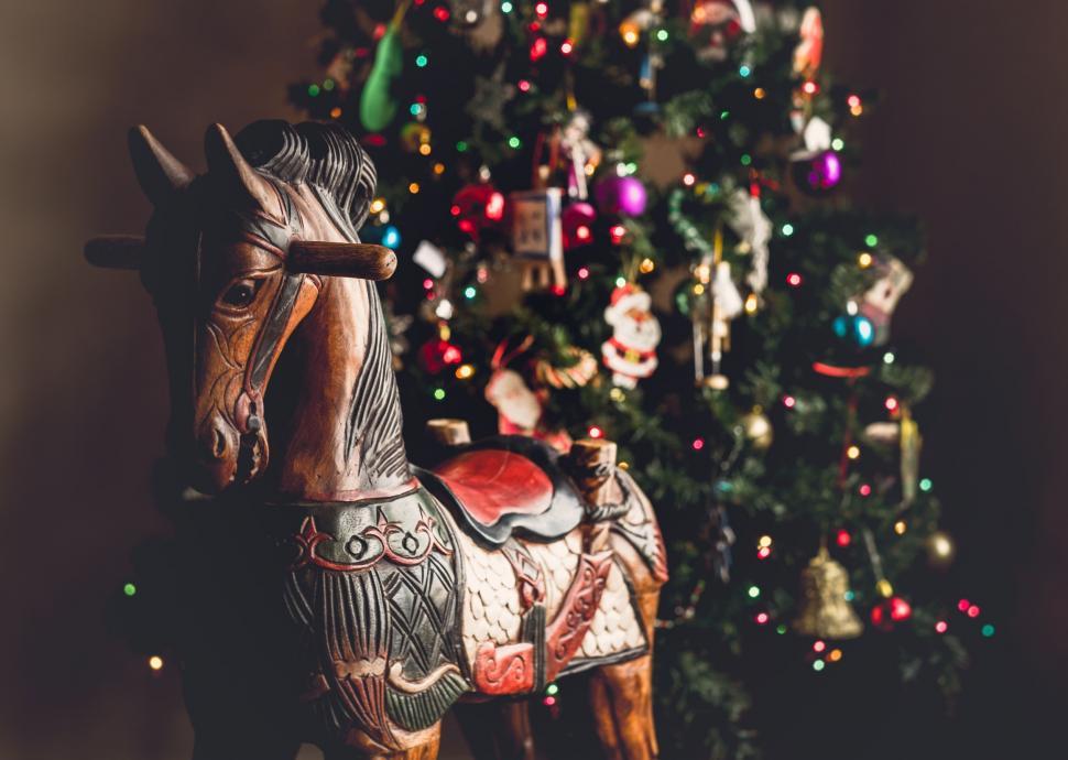 Free Image of A wooden horse with ornaments and a tree 