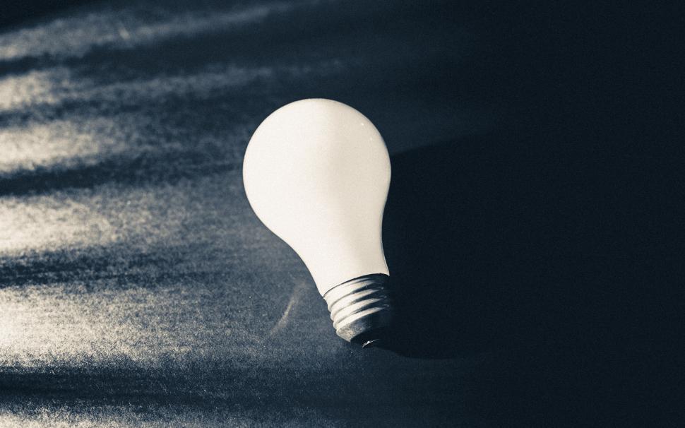 Free Image of A light bulb on a black surface 