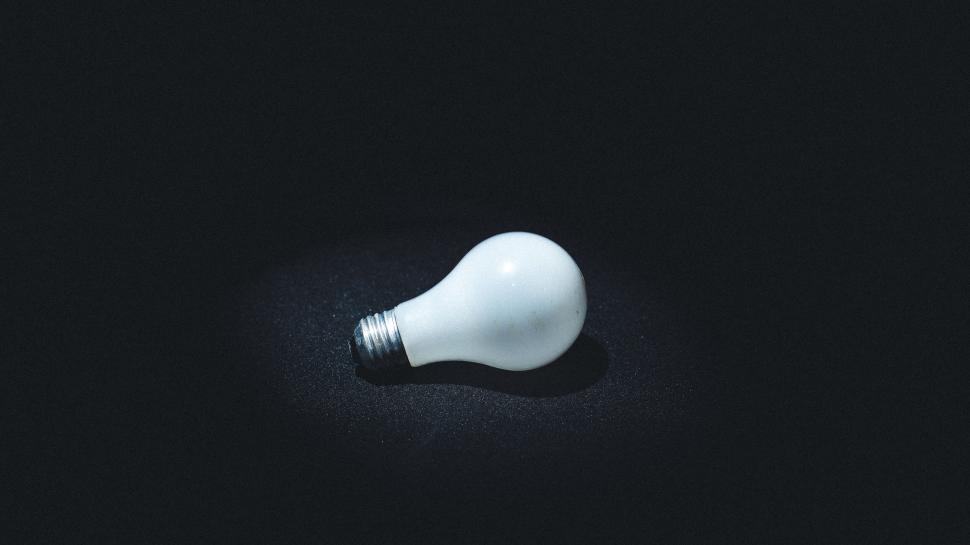 Free Image of A light bulb on a black surface 