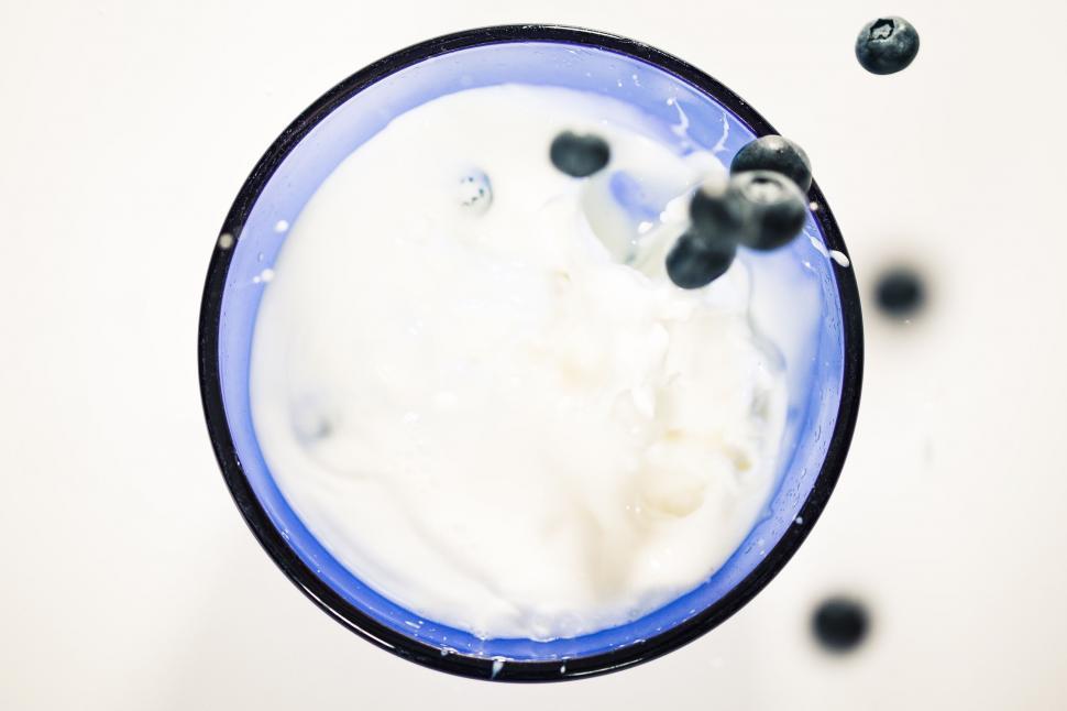 Free Image of A blueberry splashing into a glass of milk 