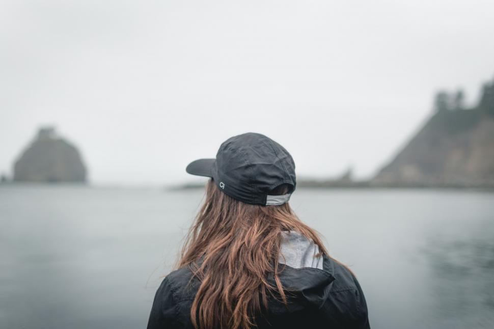 Free Image of A person wearing a hat looking at the water 