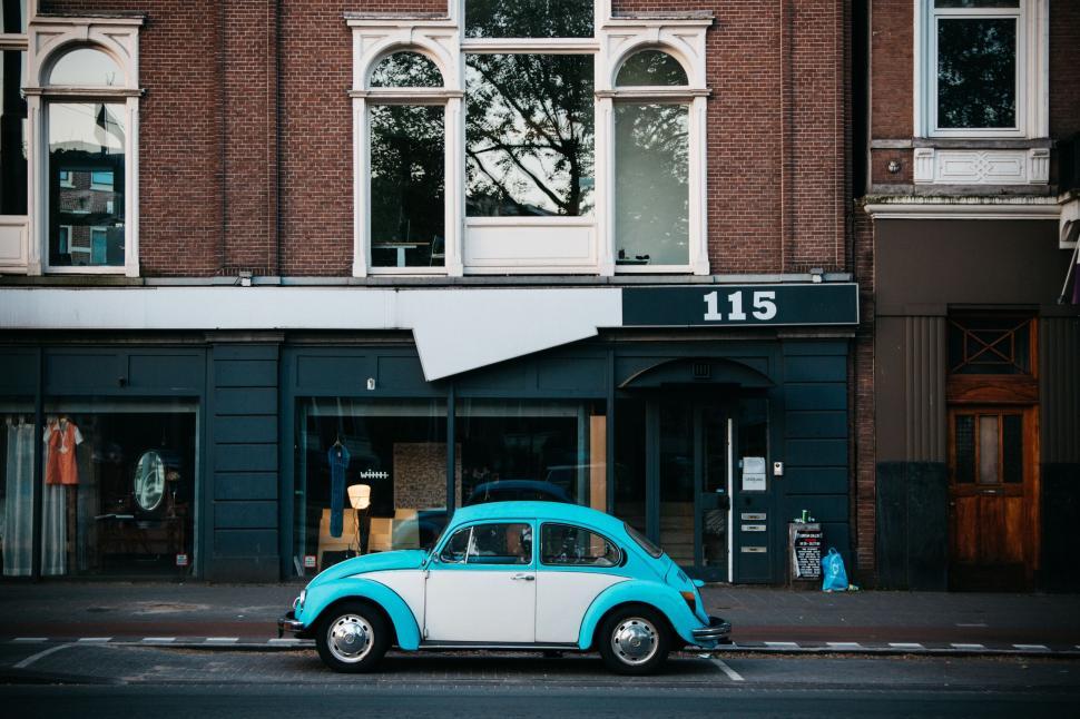 Free Image of A blue and white car parked on the side of a street 
