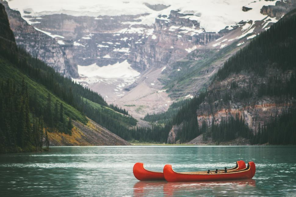 Free Image of A canoe on a lake with mountains in the background 