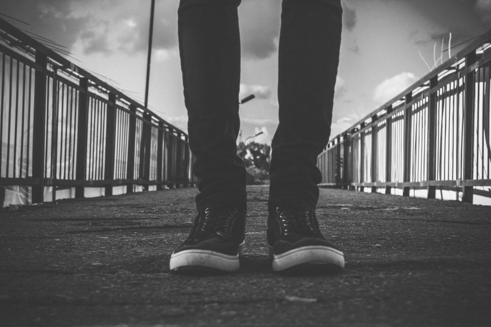 Free Image of A person s legs on a bridge 