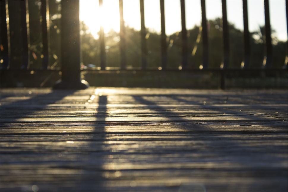 Free Image of A wood deck with a railing and trees in the background 