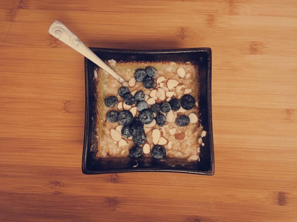 Free Image of A bowl of oatmeal with blueberries and nuts 