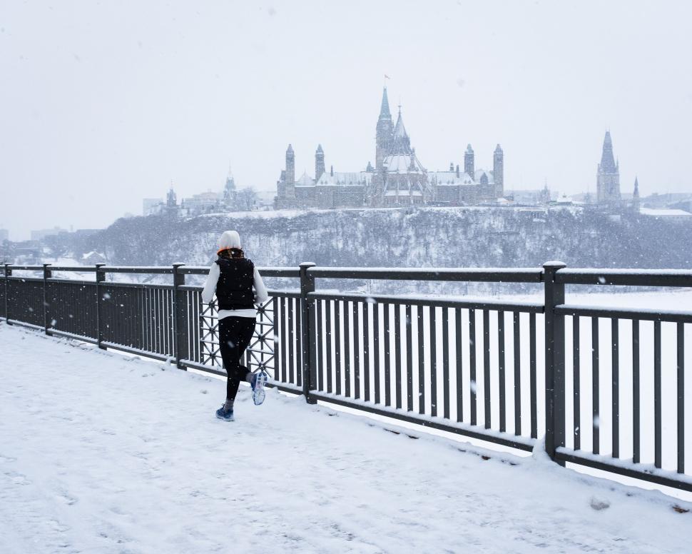 Free Image of A person walking on a bridge in the snow 