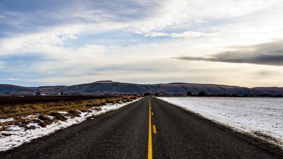 Free Image of A road with snow and mountains in the background 