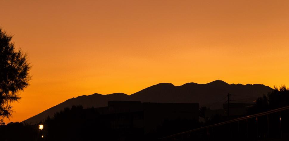 Free Image of A silhouette of a building and mountains during sunset 