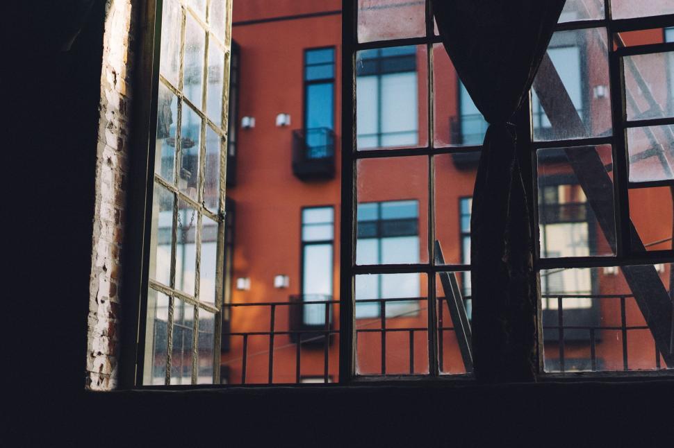Free Image of A window with a red building in the background 