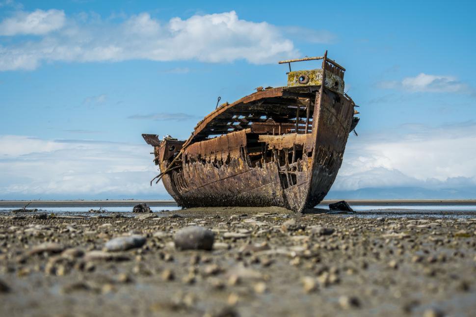Free Image of A rusted boat on a beach 