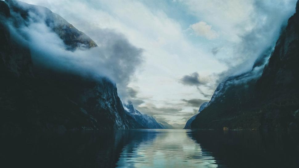 Free Image of A body of water with mountains and clouds 